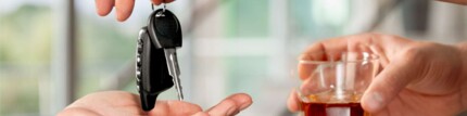 Hand mit Autoschlüssel und Alkohol, Alkohol im Verkehr