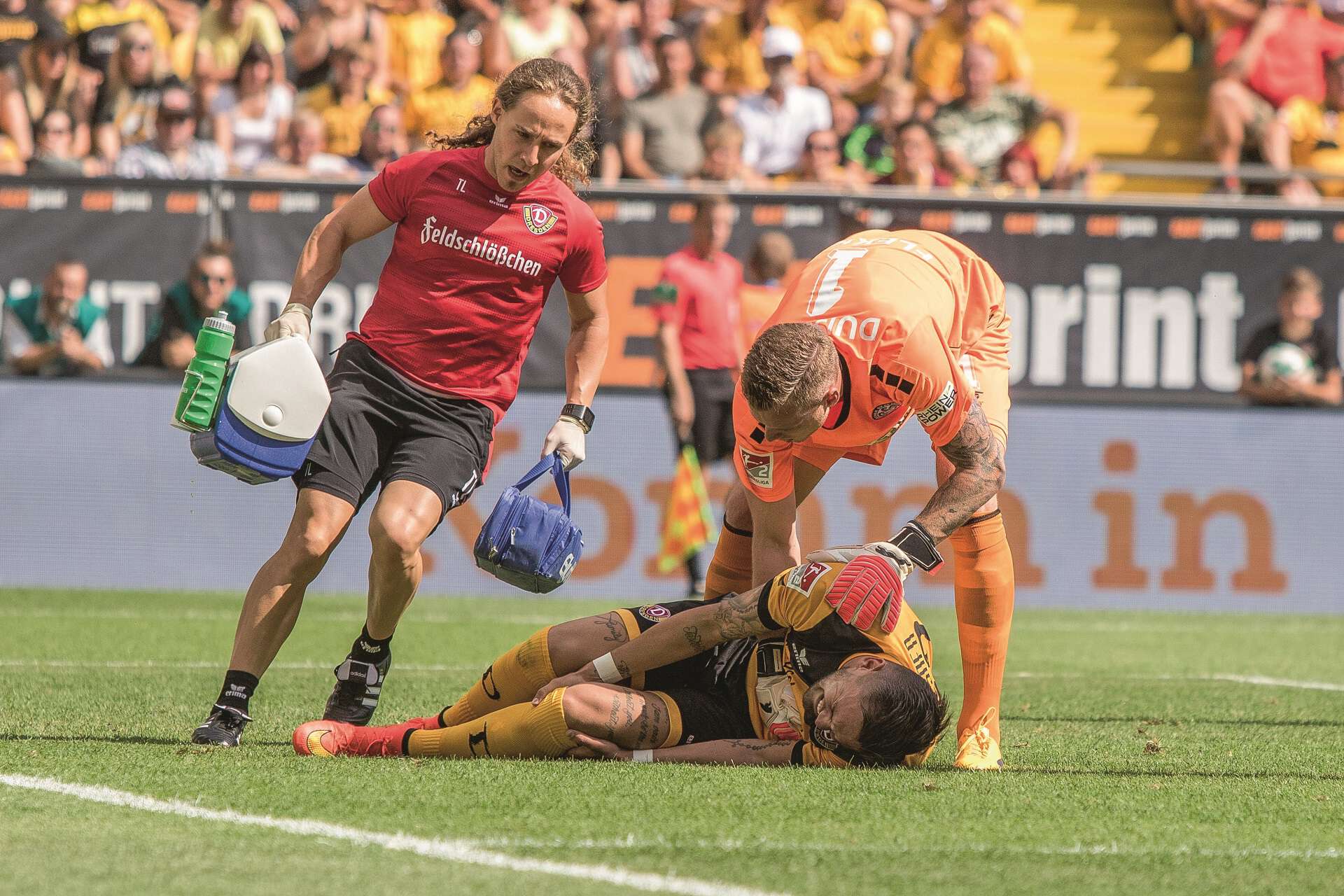 Pascal Testroet von Dynamo Dresden liegt verletzt auf dem Boden, Gegenspieler und medizinischer Betreuer kommen hinzu