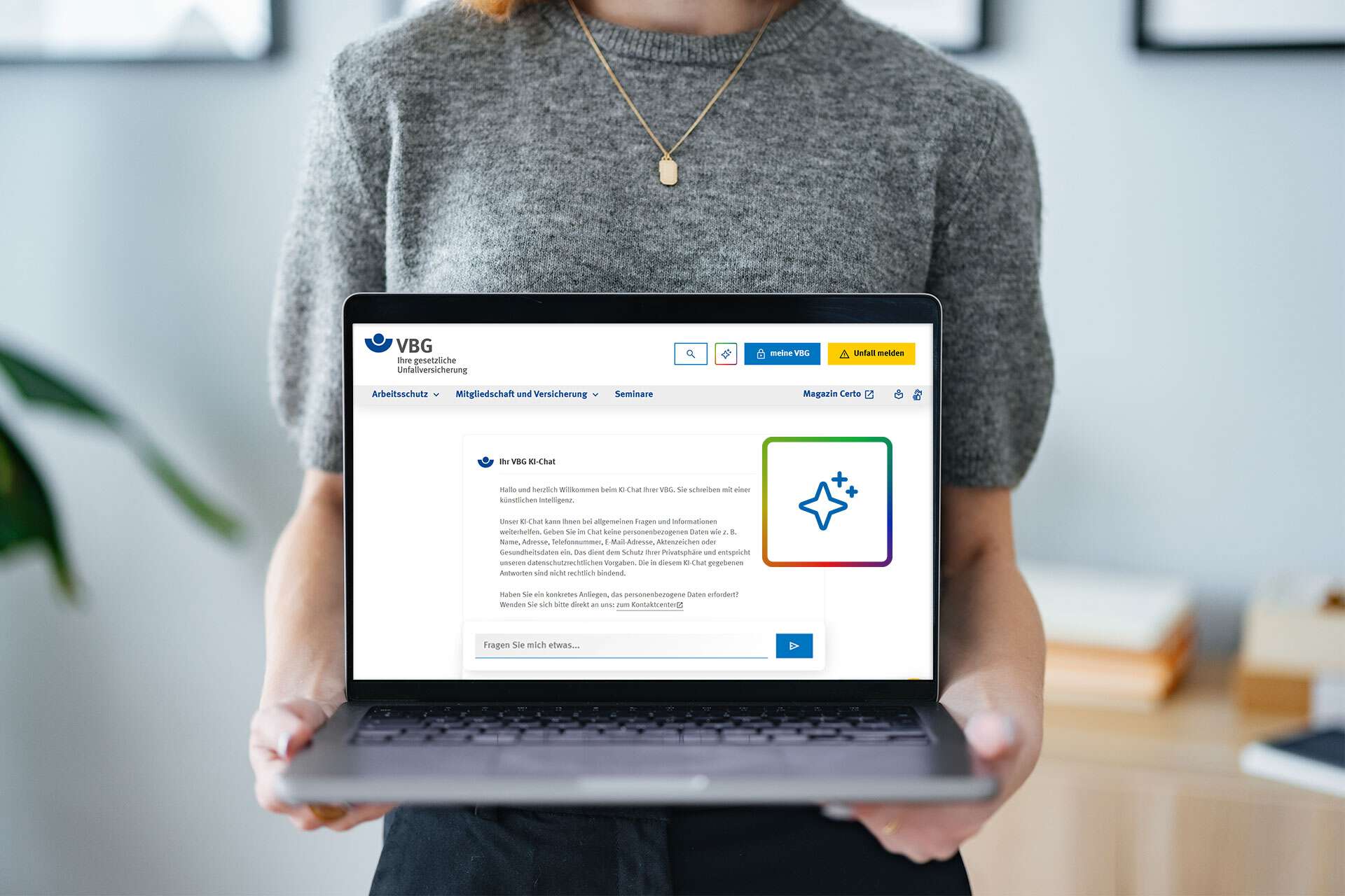 Frau zeigt VBG-Chatbot-Webseite auf Laptop