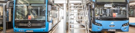 Zwei Elektrobusse stehen in einer Werkhalle
