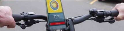 Fahradfahrer mit Handy in einer Halterung am Lenker. Die Drivometer-App wird auf dem Handy angezeigt.