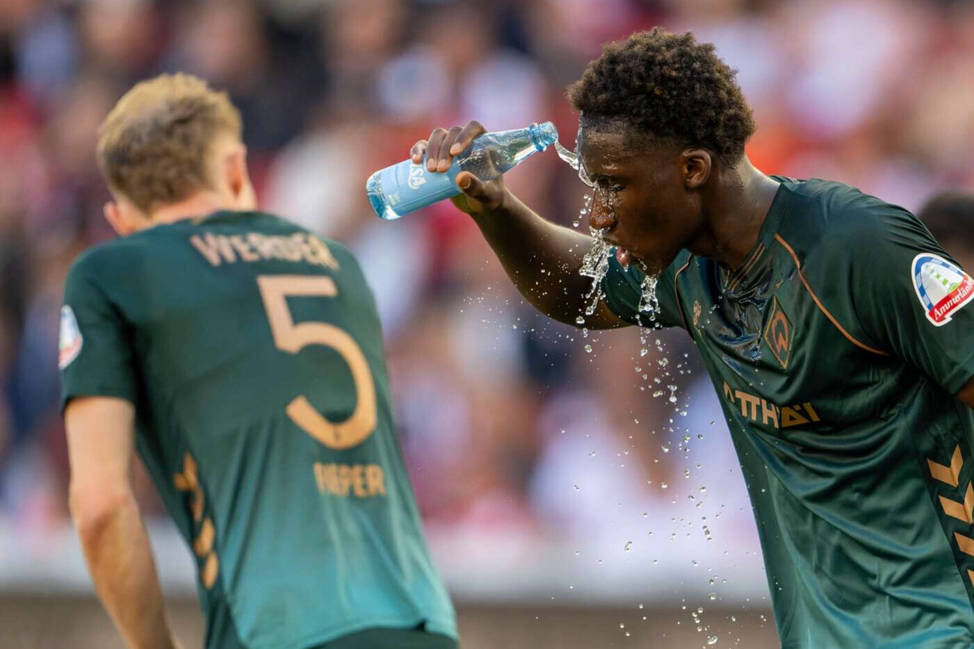 Karim Coulibaly vom SV Werder Bremen erfrischt sich während der  Bundesliga-Begegnung gegen Stuttgart mit Wasser im Gesicht, 26.04.2026