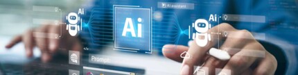 Person arbeitet an Laptop und Tablet, der Einsatz von Künstlicher Intelligenz ist durch ein in der Luft schwebendes Dashboard angedeutet.