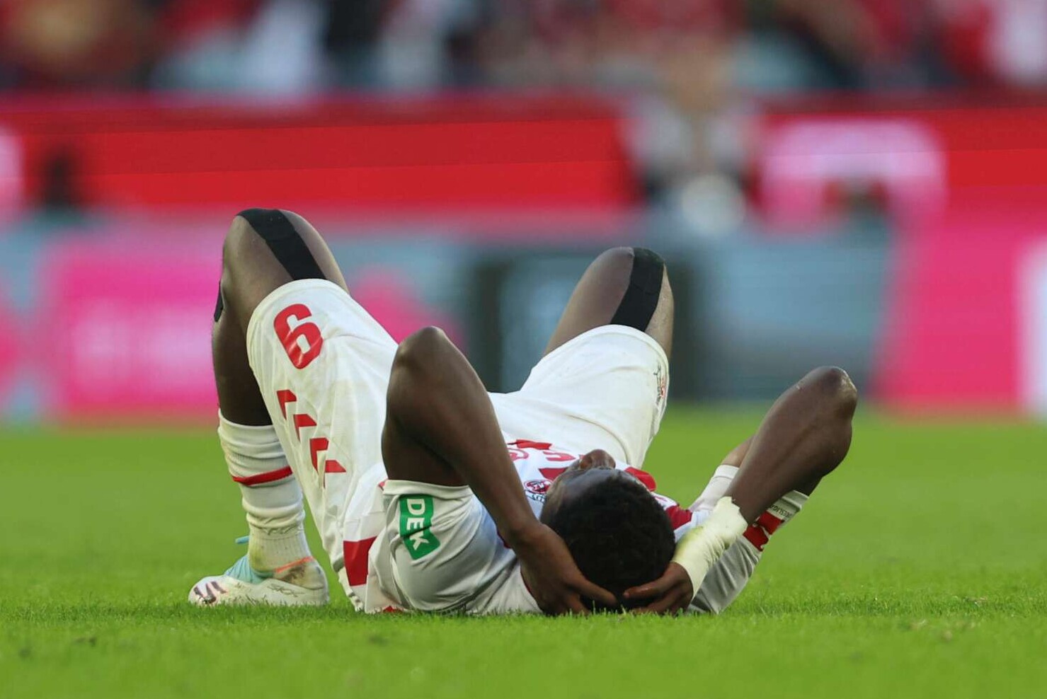 Kölns Stürmer Ragnar Ache liegt während des Bundesligaspiels zwischen dem 1. FC Köln und VfB Stuttgart verletzt am Boden , 28.09.2025