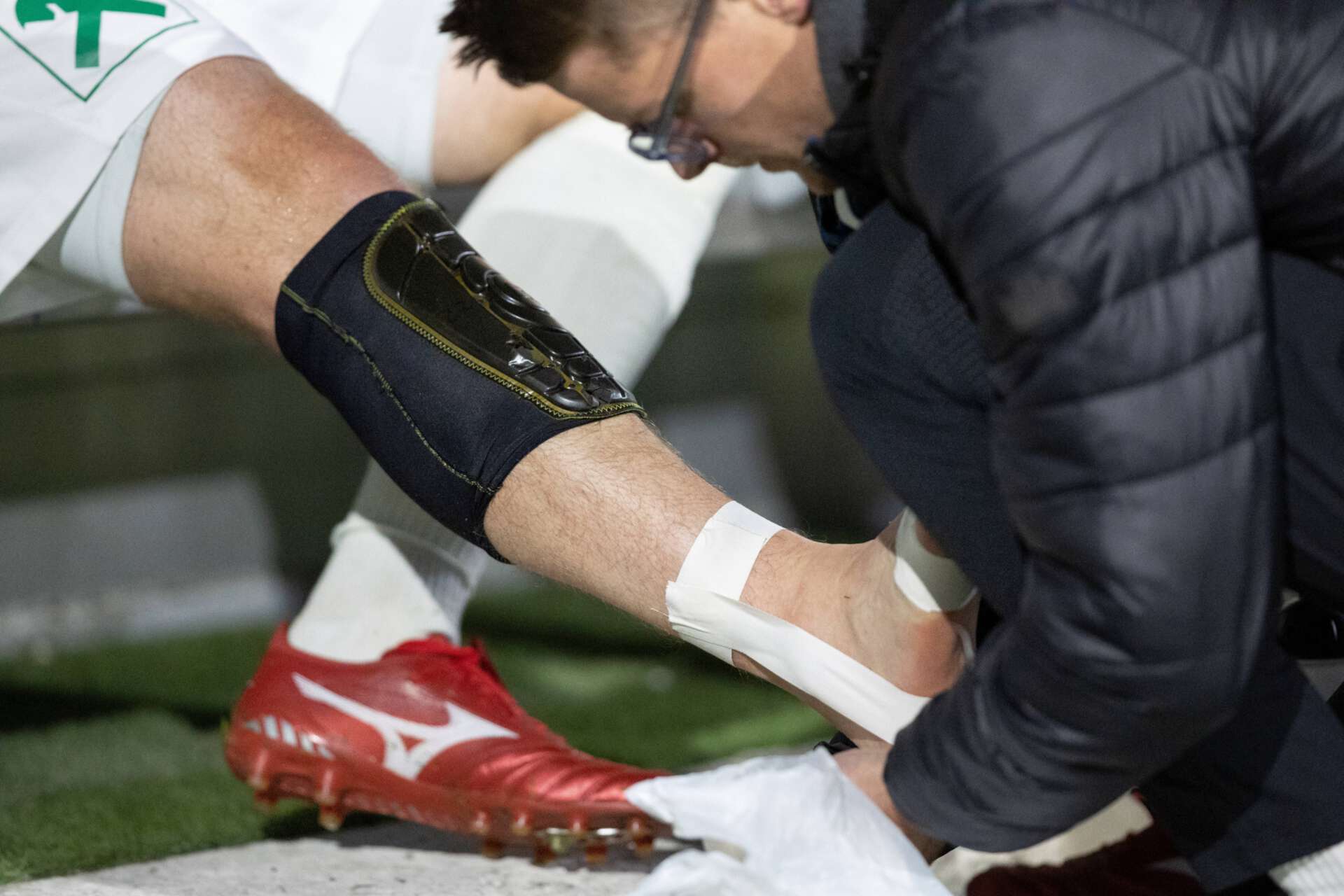 Ein verletzter Spieler wird während der Partie zwischen dem FC Wacker Innsbruck dem SV Völs mit einem Tapeverband behandelt, 21.10.2022