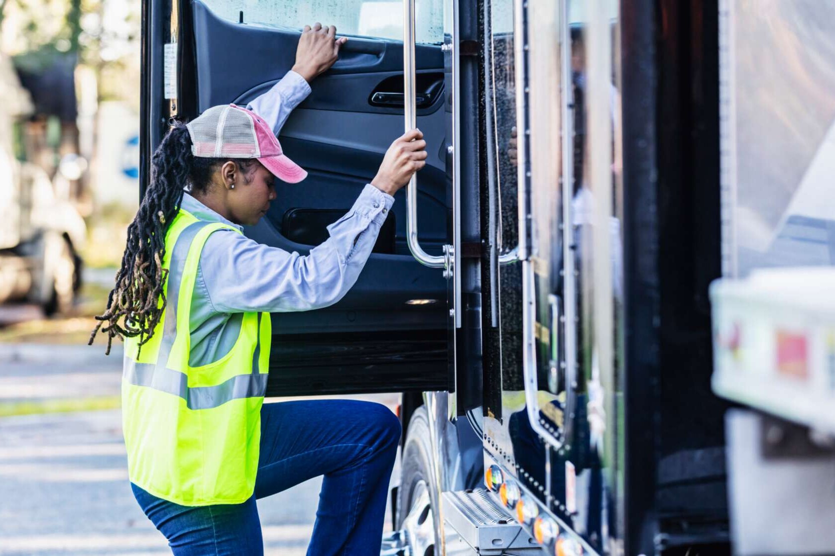 Lkw-Fahrerin klettert auf den Fahrersitz eines Sattelschleppers