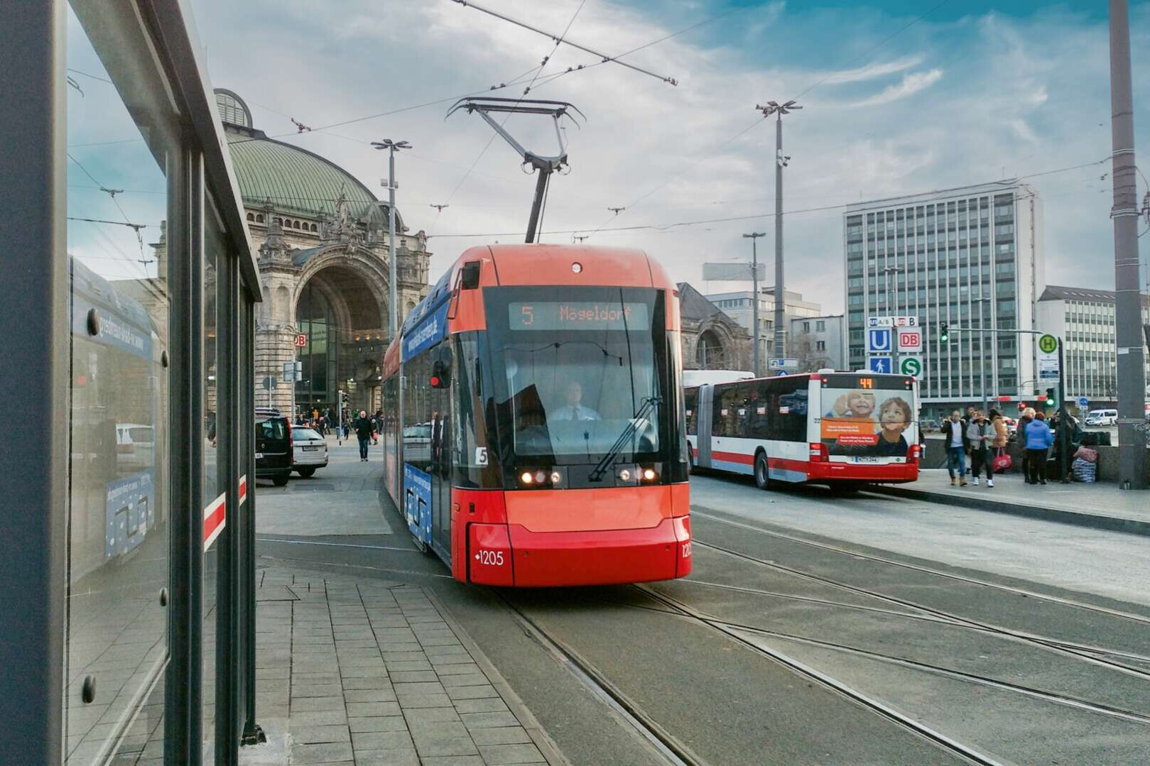 #bahnenneu Straßenbahn Nürnberg vor dem Bahnhof. Nachbearbeitetes Bild: Werbung Dritter auf Fahrzeugen/Gebäuden entfernt, Gesichter mittels KI verändert, kleinere Korrekturen, Himmel ausgetauscht.