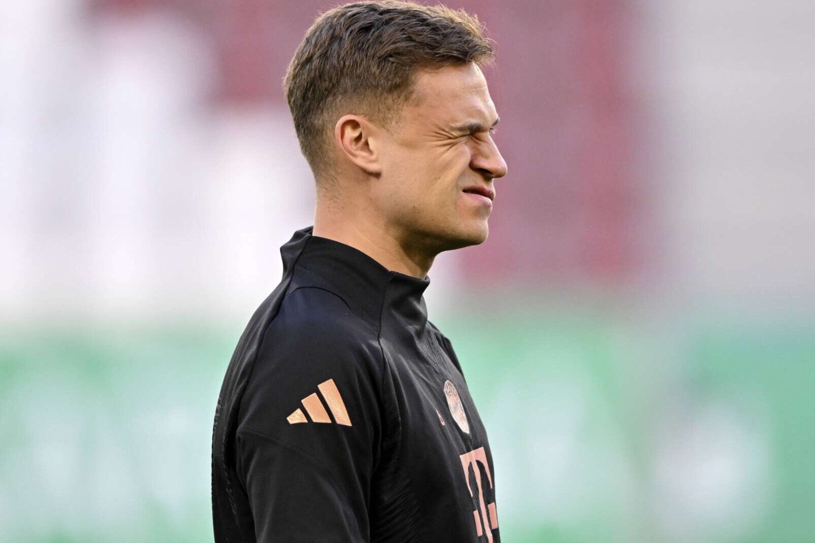 Joshua Kimmich vom FC Bayern München kneift vor der Ligapartie gegen den FC Augsburg ein Auge zu. 4.04.2025