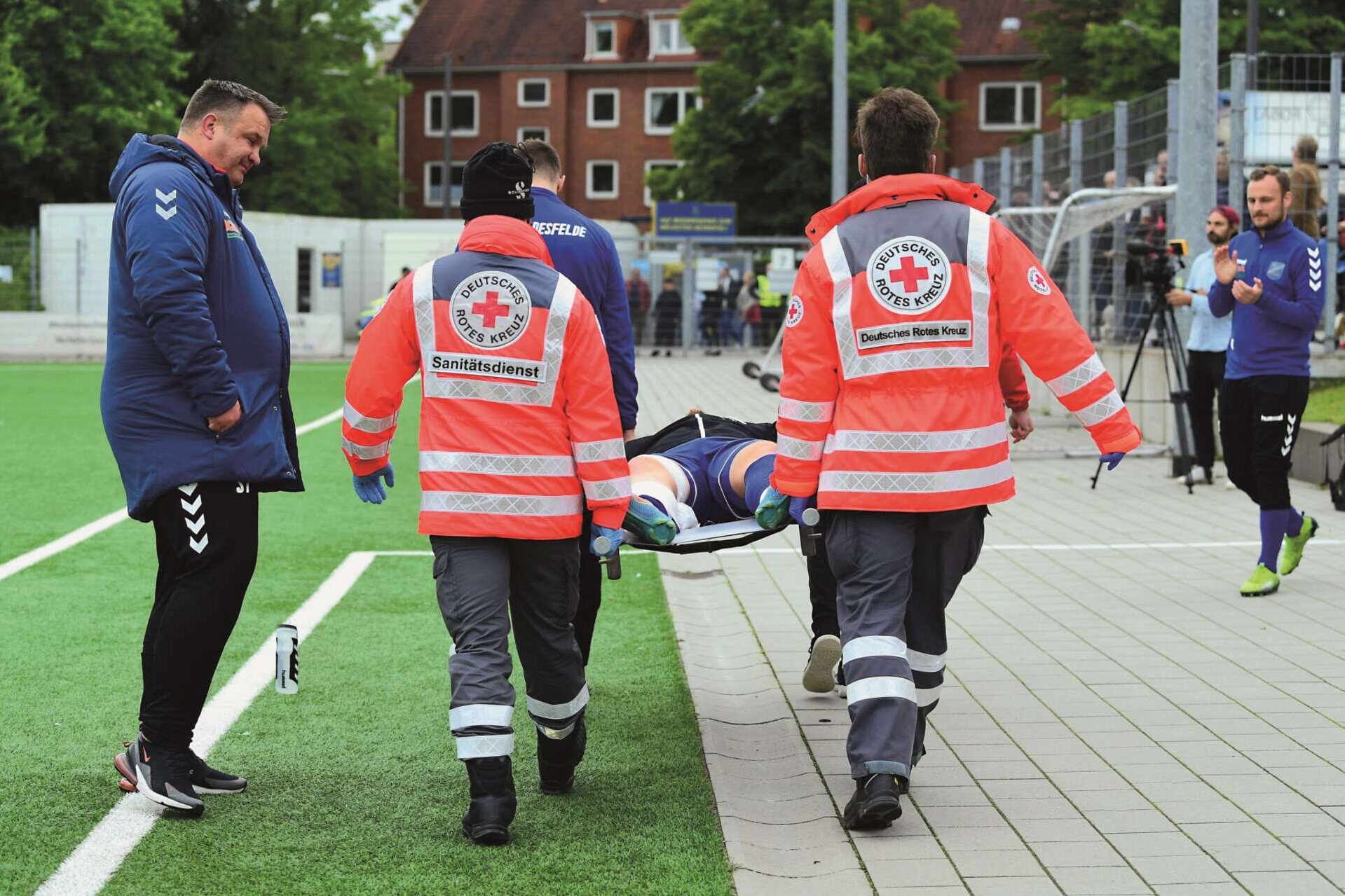 Sanitäter tragen einen verletzen Fußballer auf einer Trage