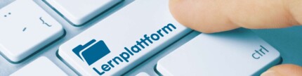 Finger klickt auf die Taste "Lernplattform" auf einer Tastatur