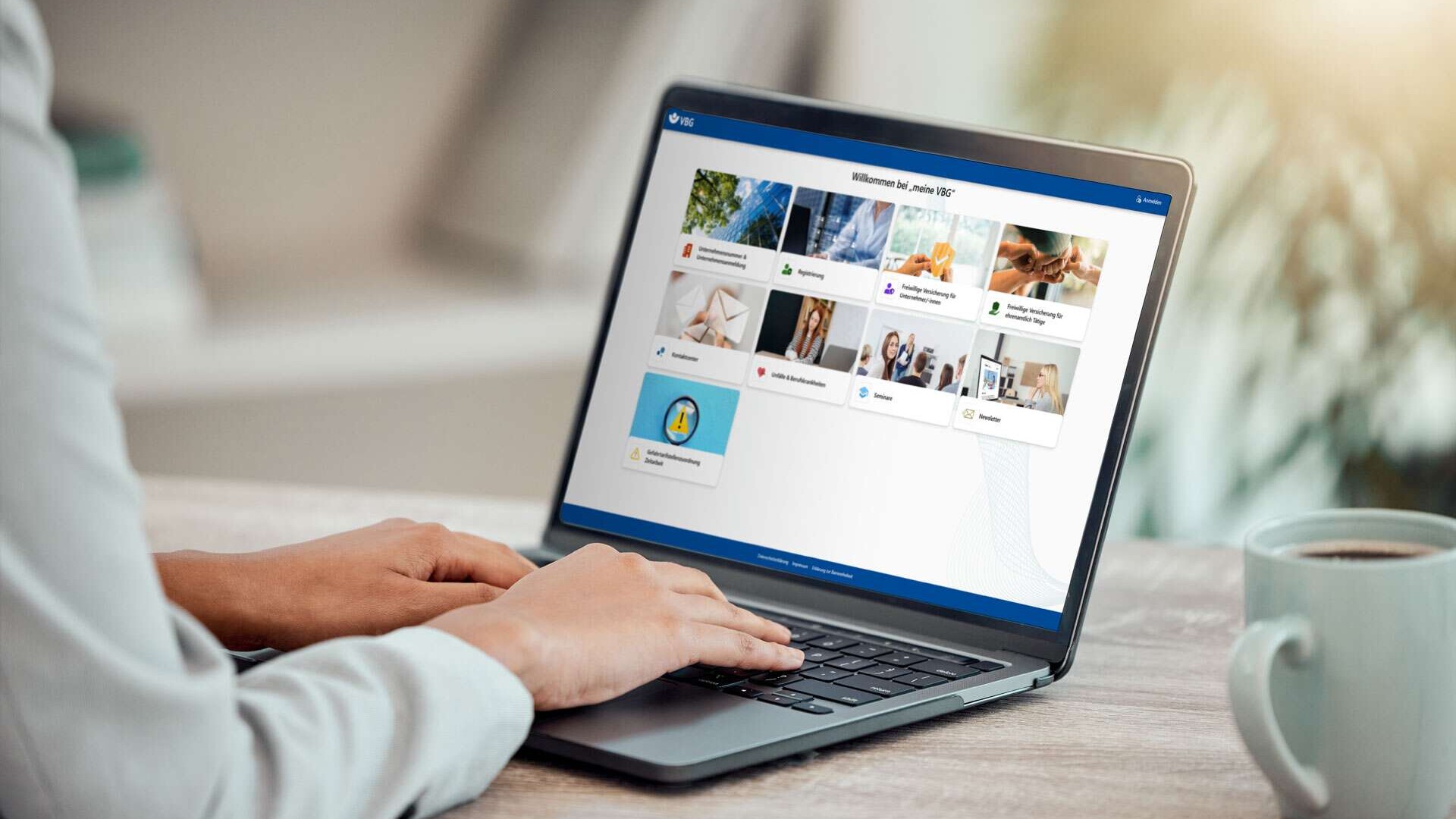 Geschäftsfrau arbeitet am Laptop, auf dem das VBG-Portal geöffnet ist