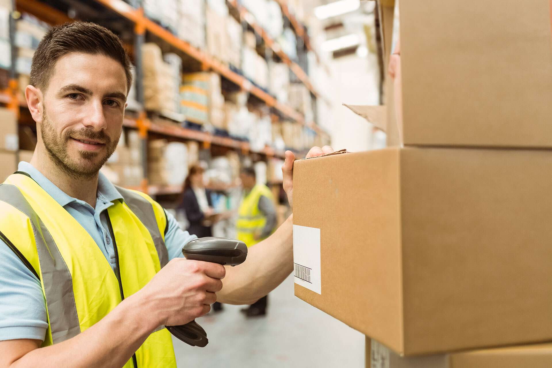 Mann scannt Barcode auf einem Karton