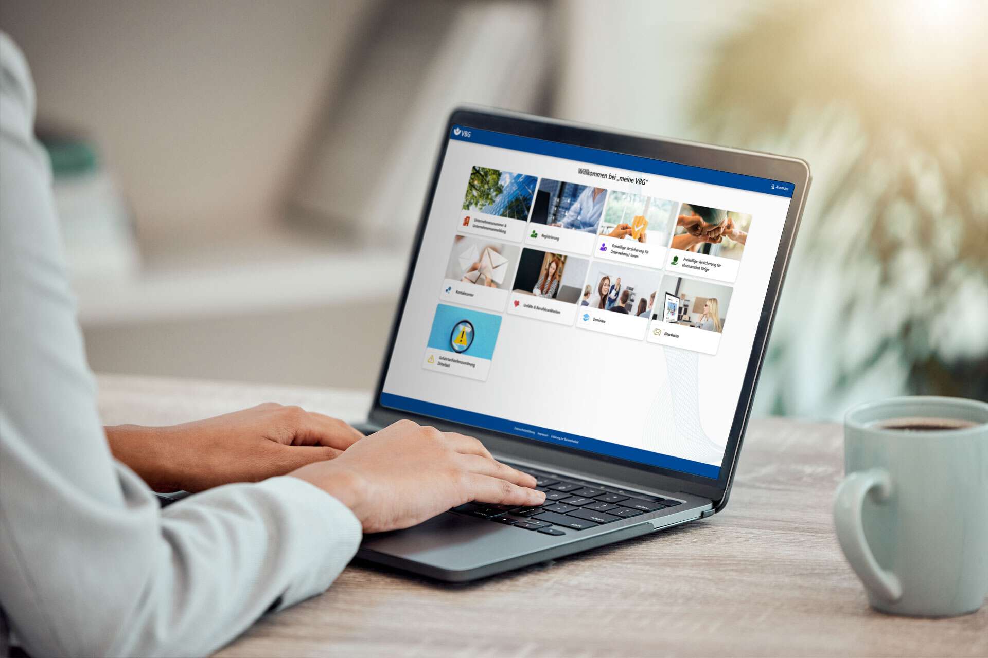 Geschäftsfrau arbeitet am Laptop, auf dem das VBG-Portal geöffnet ist