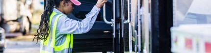 Lkw-Fahrerin klettert auf den Fahrersitz eines Sattelschleppers 