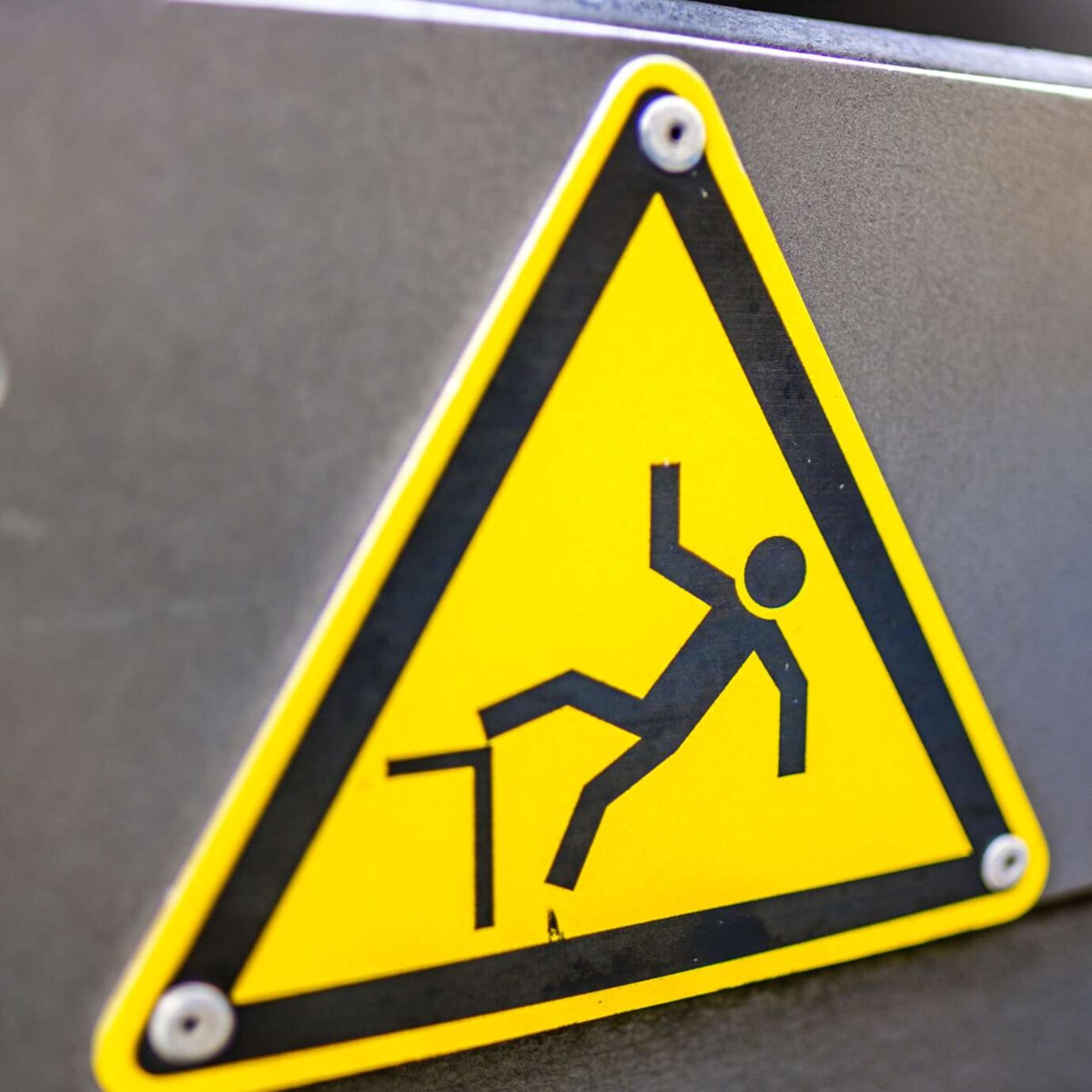 "Achtung Absturzgefahr" Warnschild an einem grauen Geländer