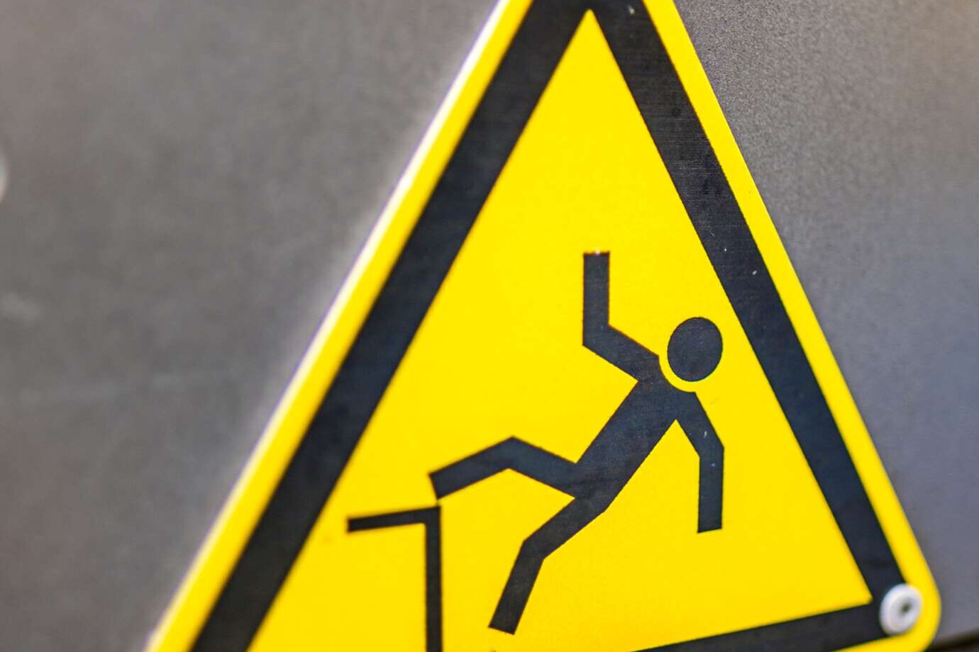 "Achtung Absturzgefahr" Warnschild an einem grauen Geländer