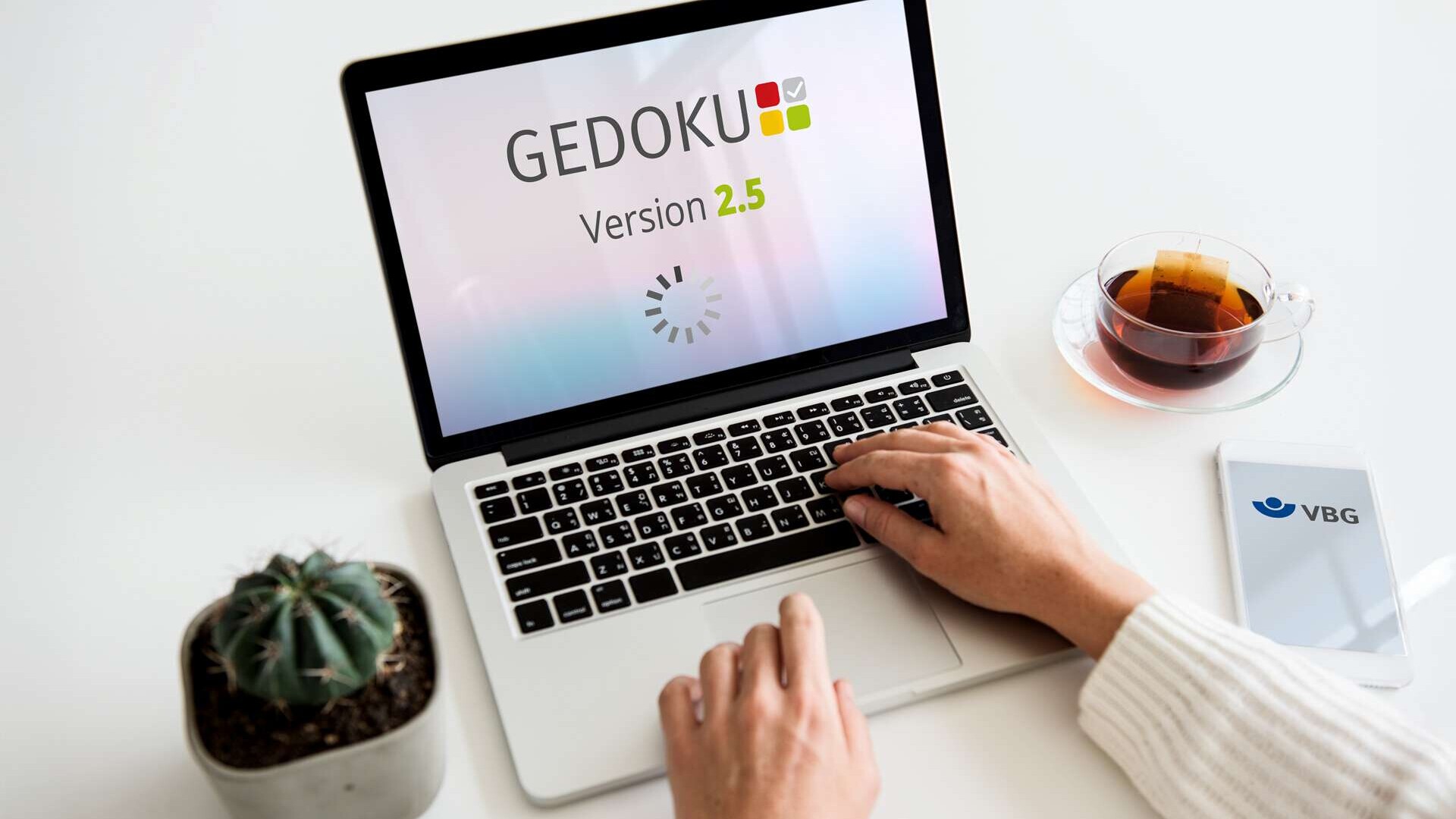 GEDOKU 2.5 - Mockup auf einem Laptop-Bildschirm ; am Laptop arbeitet eine Person, von der nur die Hände im Bild zu sehen sind.
