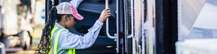 Lkw-Fahrerin klettert auf den Fahrersitz eines Sattelschleppers