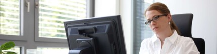 Beschäftigte sitzt nachdenklich am Bildschirmarbeitsplatz
