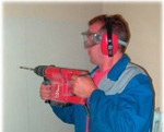 Bohrende Personen mit Schutzbrille und Gehörschutzkapseln
