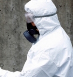 Person mit Schutzanzug, Atemschutz und Schutzbrille