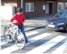 Radfahrer schiebt sein Rad über einen Zebrastreifen