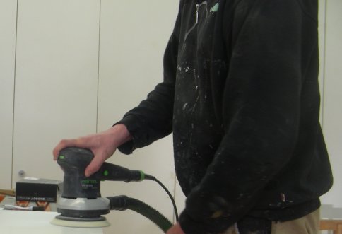Person arbeitet mit einer Schleifmaschine