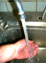 Hand wird unter fließendem Wasser gehalten