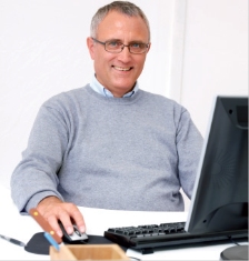 Mann mit Brille am Bildschirmarbeitsplatz